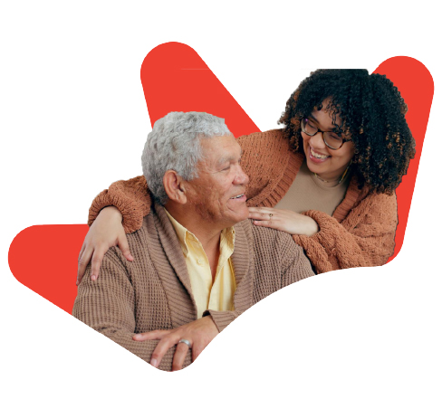 An older man and a younger woman smiling at each other. The woman has her arm around his shoulder, set against a red abstract spark shape.